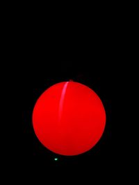 Close-up of illuminated red lights against black background