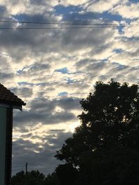 Low angle view of silhouette trees against sky