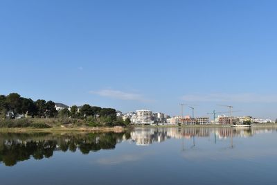 Reflection of building on lake against sky