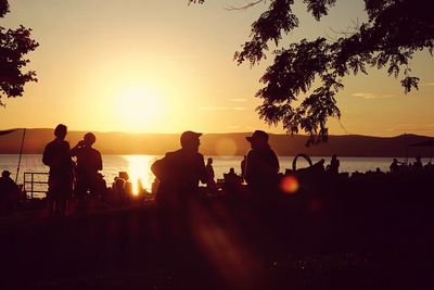 Silhouette of people in sea at sunset