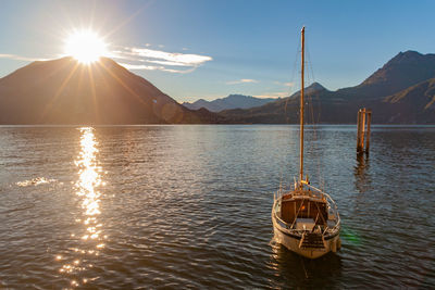 A boat is resting at sunset on water of lake como, lombardia, italy