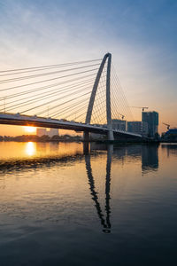 Bridge over river against sky during sunset