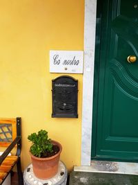 Text on closed door of yellow building