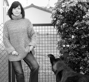 Portrait of woman with dog against plants