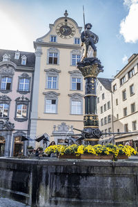 Low angle view of statue against buildings in city