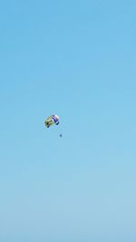 Low angle view of kite flying against clear blue sky