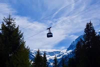 Low angle view of overhead cable car against sky