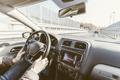 Cropped image of man driving car in city