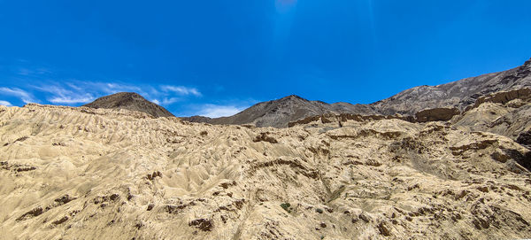 Scenic view of rocky mountains against blue sky