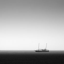 Sailboat sailing on sea against clear sky