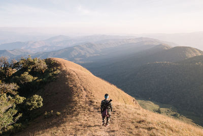 Rear view of man on mountain against sky