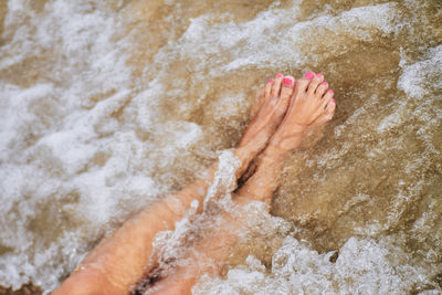 Low section of woman in sea