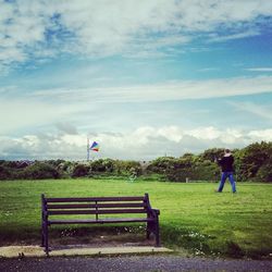 Rear view of man sitting on grassy field