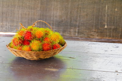 High angle view of fresh red flowers in basket on table