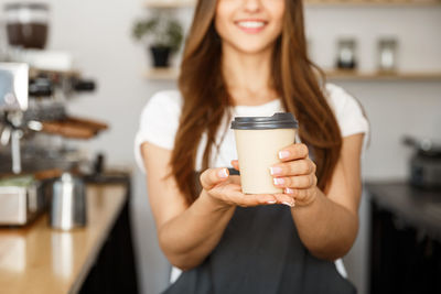 Midsection of woman holding coffee cup