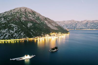 Scenic view of sea and mountains against clear sky