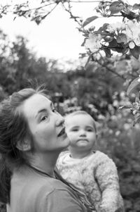 Portrait of mother and daughter against trees