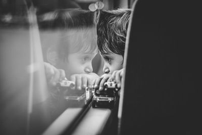 Close-up portrait of boy looking through window