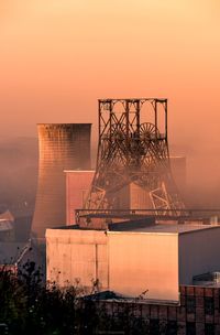 View of factory against sky during sunset