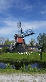 Traditional windmill on field against sky