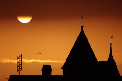Low angle view of silhouette built structure at sunset