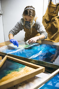 Female resin working in homemade studio