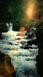 Scenic view of waterfall against sky during sunset