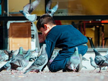 Little boy feeding pigeons