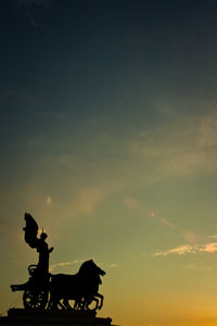 Silhouette people riding horse against sky during sunset