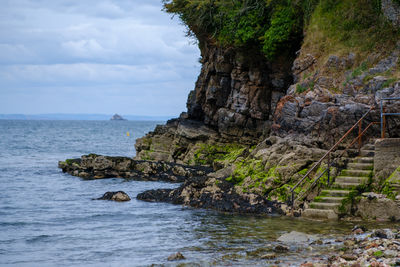 Rock formation amidst sea against sky