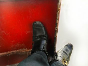 Low section of man standing on red floor