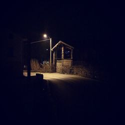 Illuminated street light on road at night