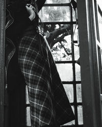 Close-up of woman standing by window