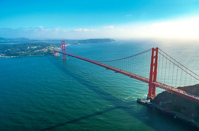 Suspension bridge over sea against sky