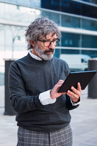 Senior businessman with eyeglasses working on digital tablet