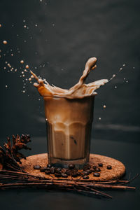 Close-up of coffee splashing in glass on table