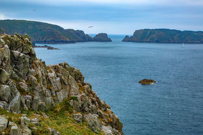 Scenic view of sea and mountains against sky