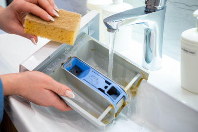 Cropped image of man washing hands in sink