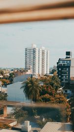 Buildings by swimming pool in city against sky