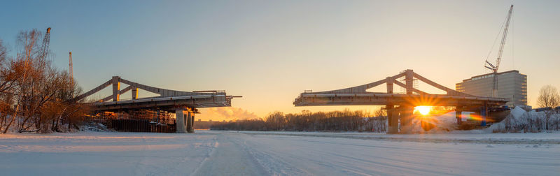 Low angle view of suspension bridge against sky during sunset