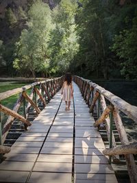 Rear view of woman on footbridge