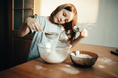 A girl cooks a pie in the kitchen, isolation exercise for a child
