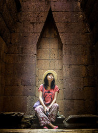 Woman sitting against wall