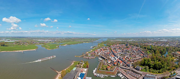 High angle view of city by sea against sky