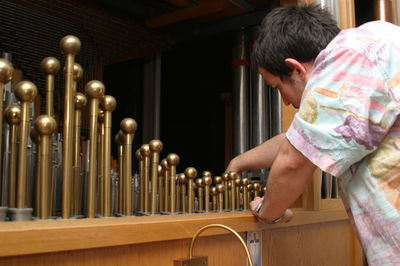 Rear view of man holding candles in temple