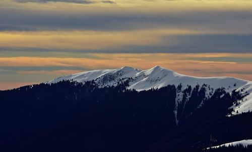 Scenic view of snowcapped mountains against sky during sunset