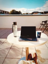 Coffee cup on table against sky