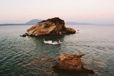 Rock formations by sea against clear sky