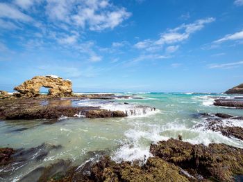 Scenic view of rocky shoreline against sky