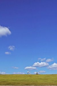 Scenic view of agricultural field against blue sky